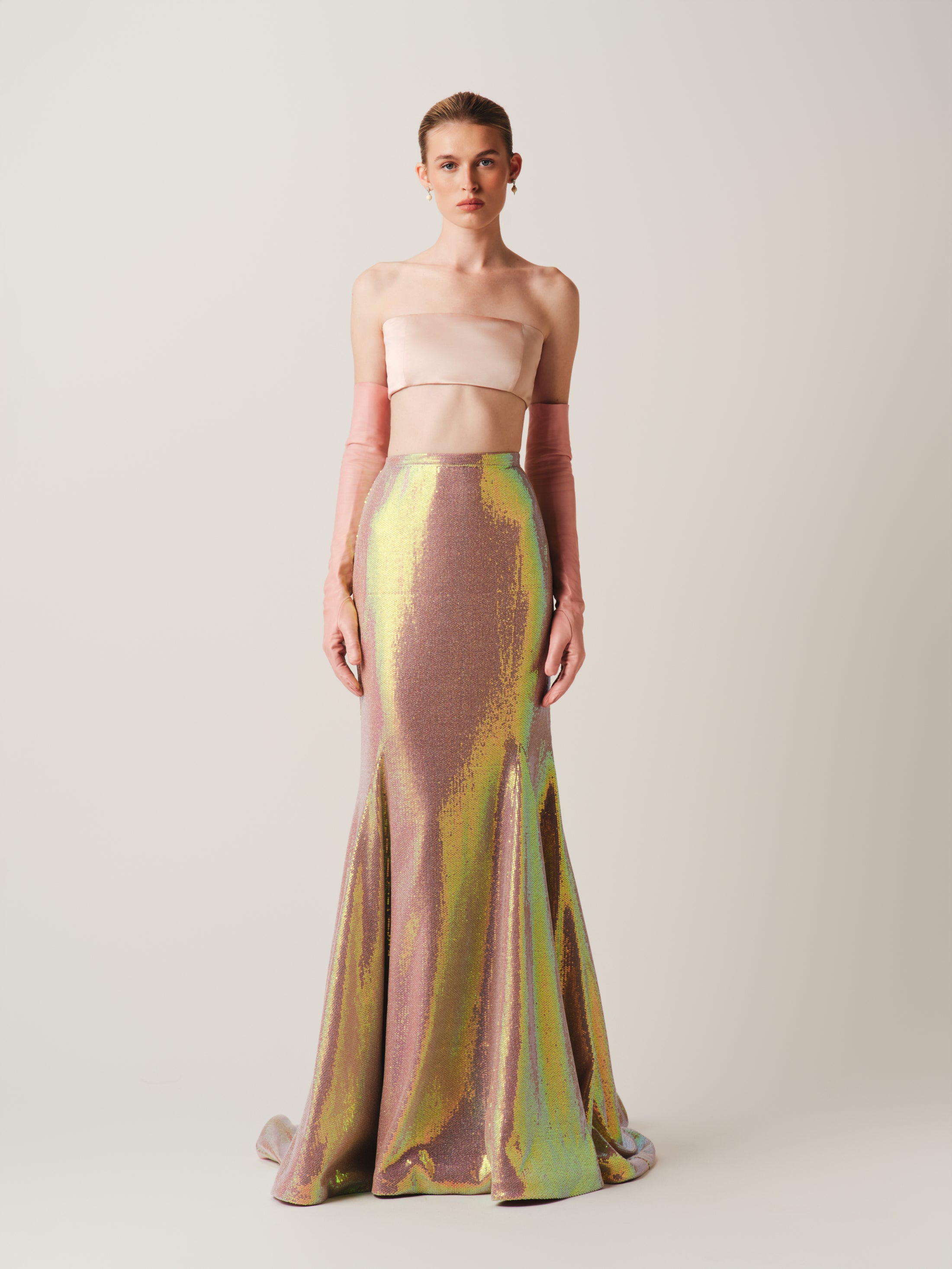 Model wearing a strapless top and colorful mermaid-style skirt on a plain background