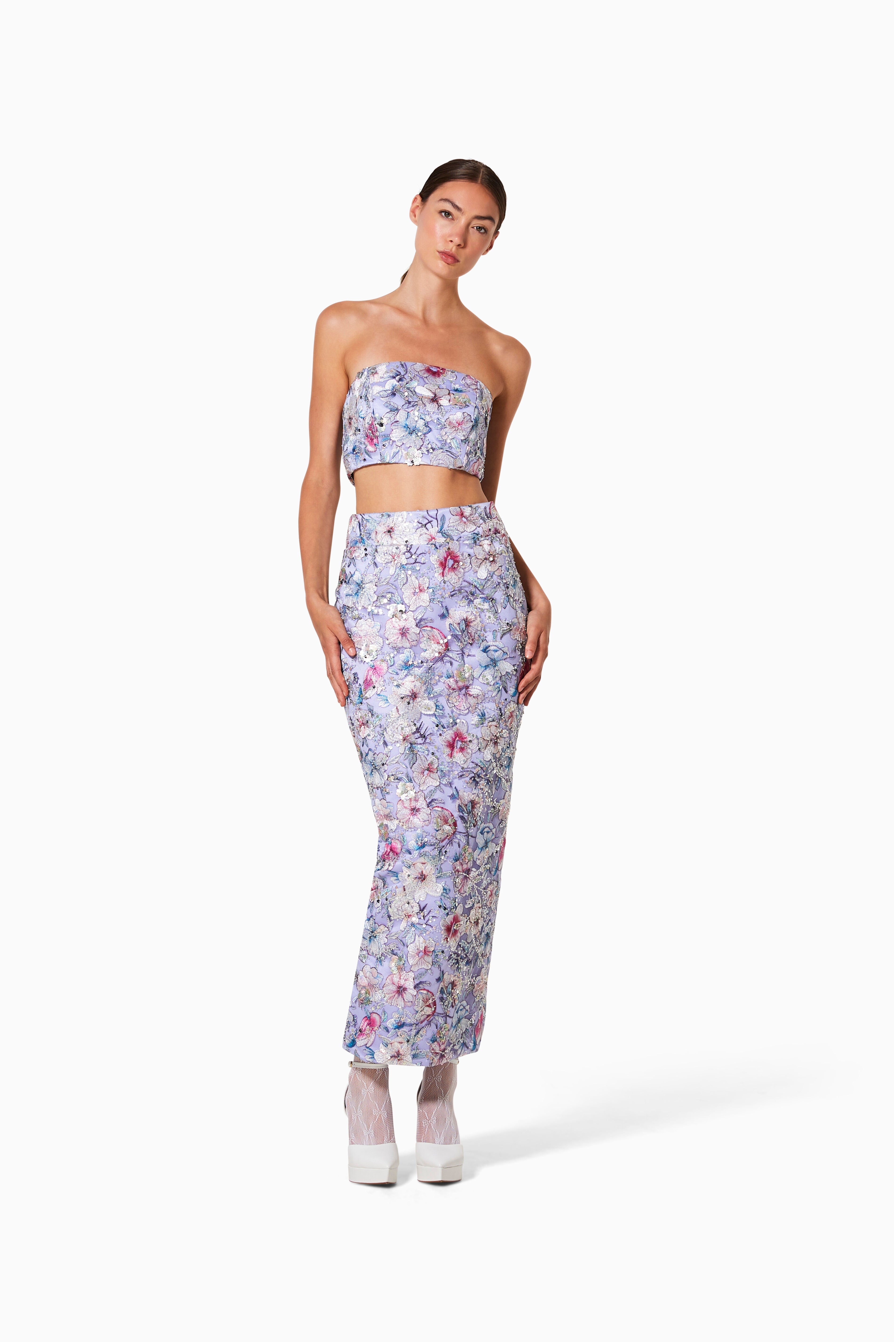 A model wearing a floral two-piece set with a pencil skirt and banjo top.