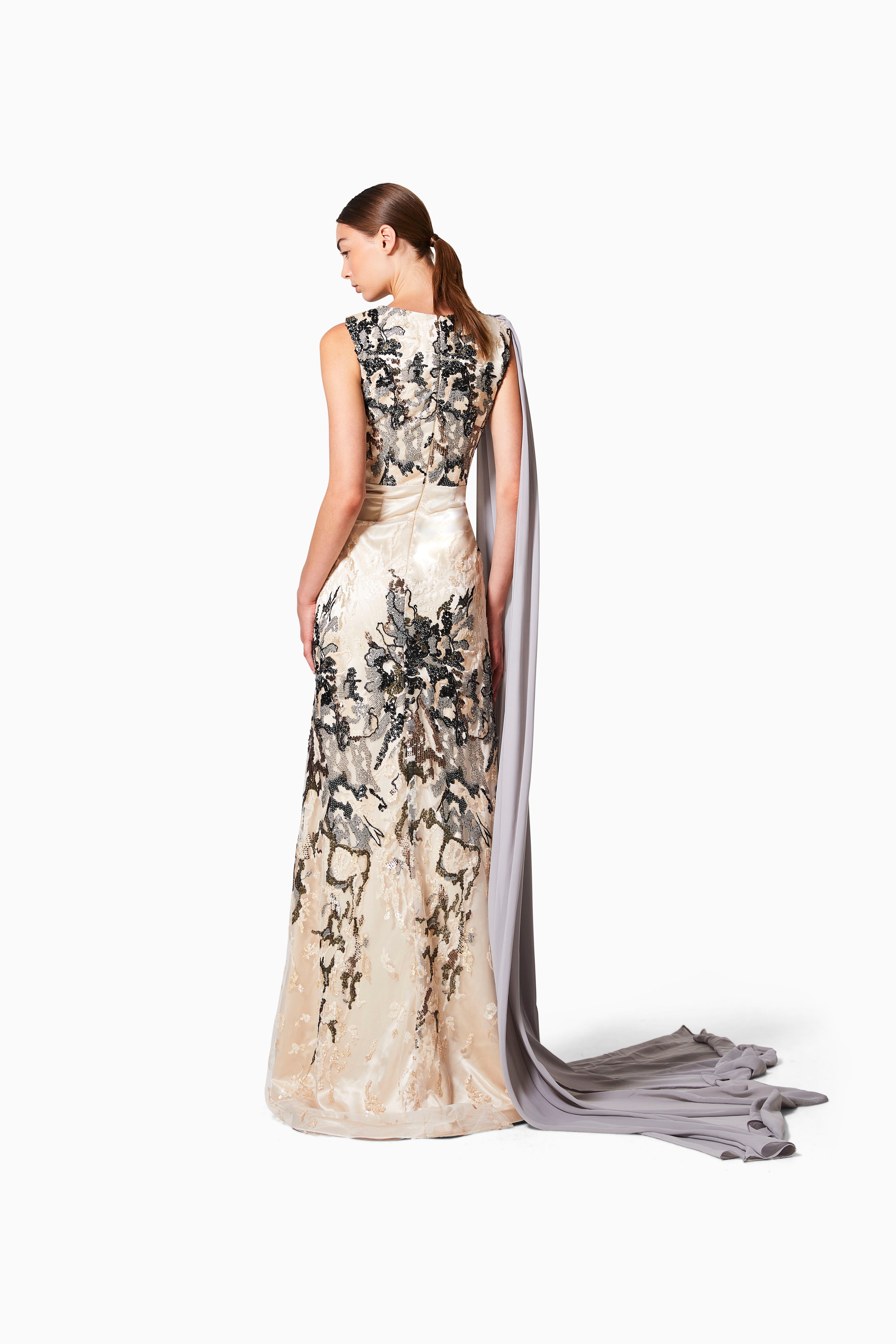 Elegant evening gown with floral pattern and long train on a white background