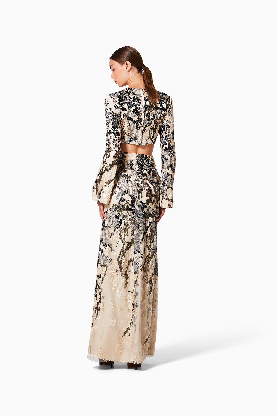 Woman wearing a long, patterned dress on a white background