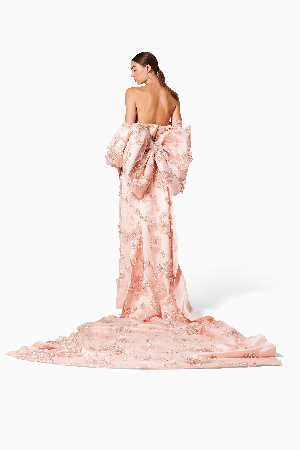 Woman wearing a pink floral gown on a white background
