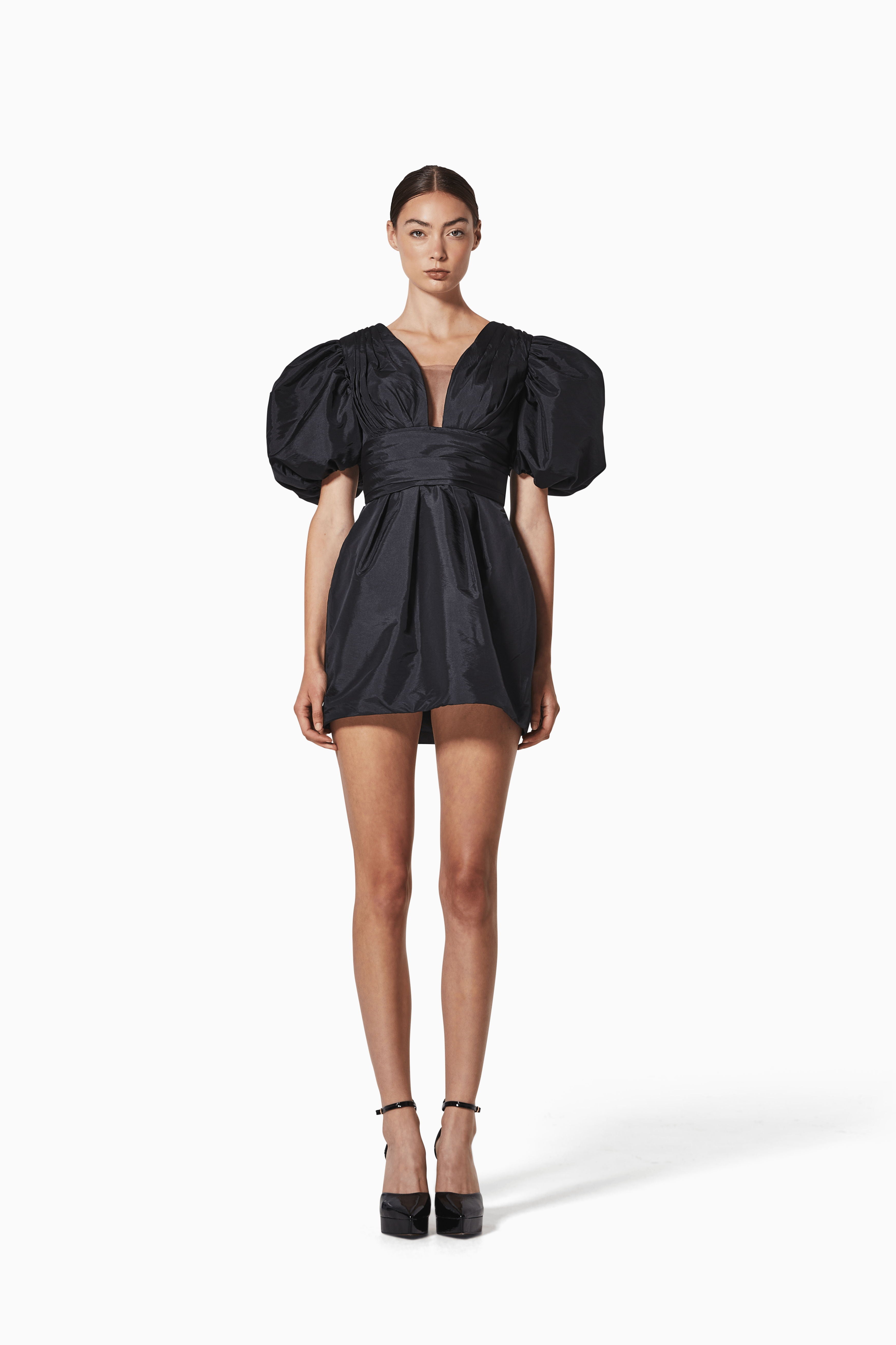 Black puff-sleeve dress worn by a model on a white background